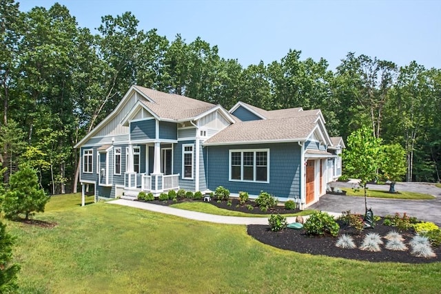 view of front of property with a garage, a front yard, and a porch