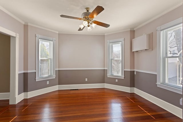 spare room with ceiling fan, wood finished floors, baseboards, and ornamental molding