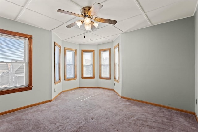 spare room with baseboards, plenty of natural light, light carpet, and ceiling fan