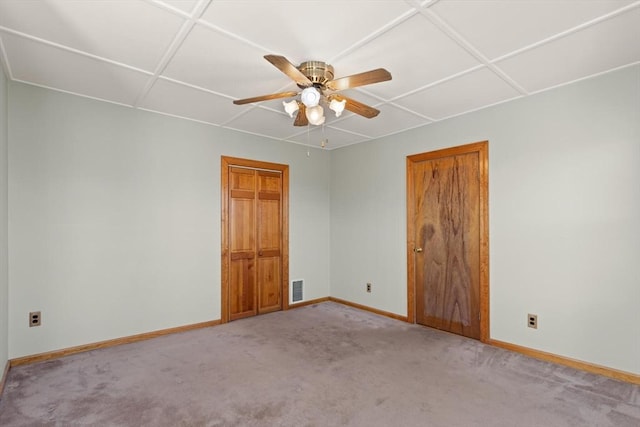 empty room featuring visible vents, baseboards, carpet, and ceiling fan