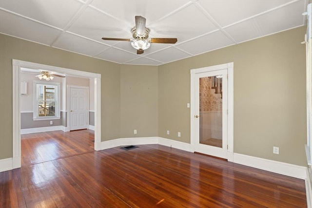 empty room featuring visible vents, coffered ceiling, wood-type flooring, baseboards, and ceiling fan