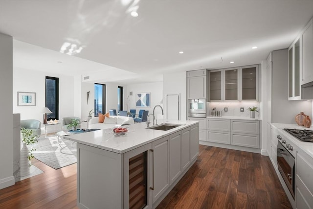 kitchen with dark wood-style flooring, beverage cooler, a sink, and open floor plan