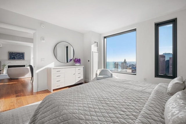 bedroom with a fireplace and wood finished floors