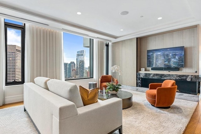 sitting room with ornamental molding, wood finished floors, and recessed lighting