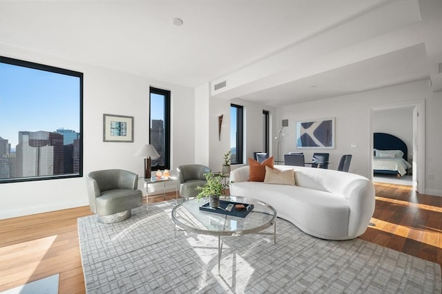 living area featuring visible vents and wood finished floors