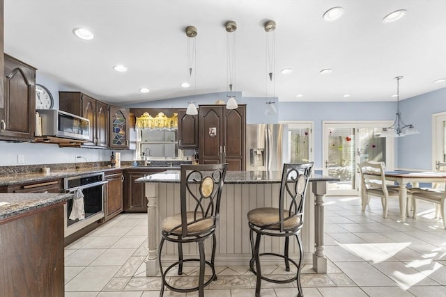 kitchen featuring pendant lighting, light tile patterned floors, stainless steel appliances, and a kitchen island