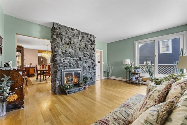 living room featuring a fireplace, a notable chandelier, and wood-type flooring