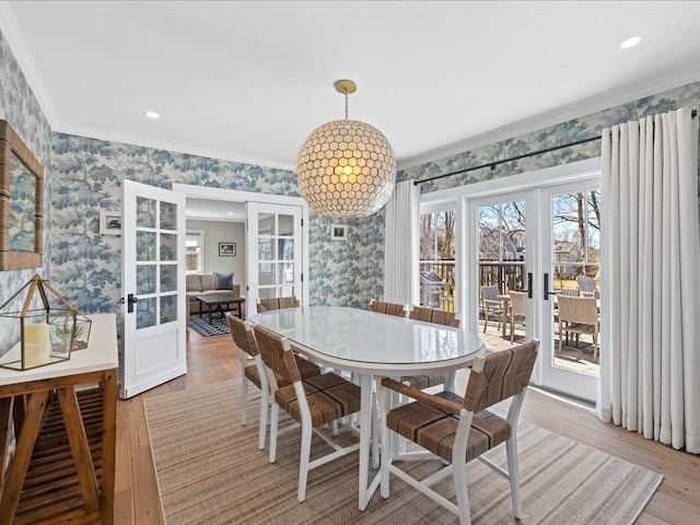 dining area featuring ornamental molding, french doors, and light hardwood / wood-style flooring