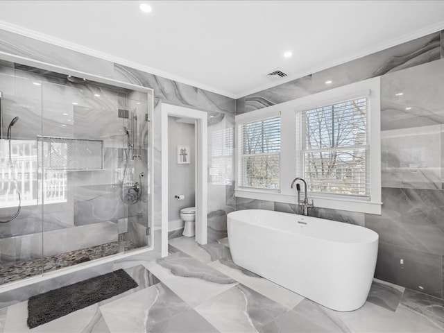 bathroom with toilet, tile walls, crown molding, and separate shower and tub