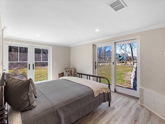 bedroom featuring french doors, light hardwood / wood-style floors, multiple windows, and crown molding