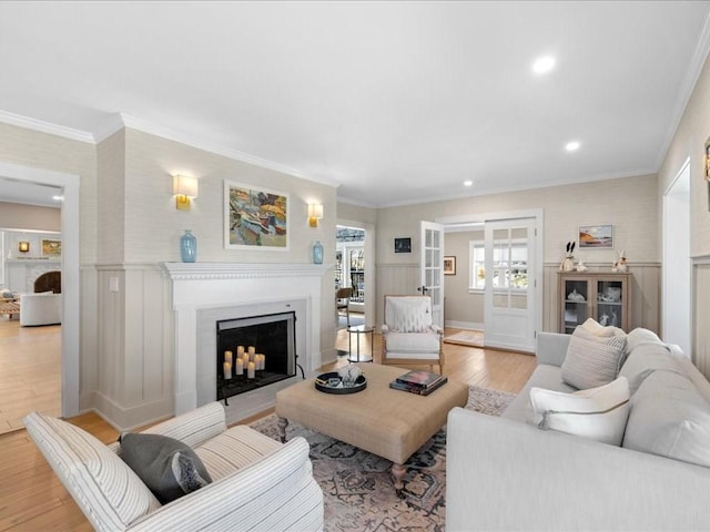 572 Jerusalem Rd, Cohasset, MA 02025 - living room featuring light wood-type flooring, a fireplace, a wainscoted wall, a decorative wall, and crown molding