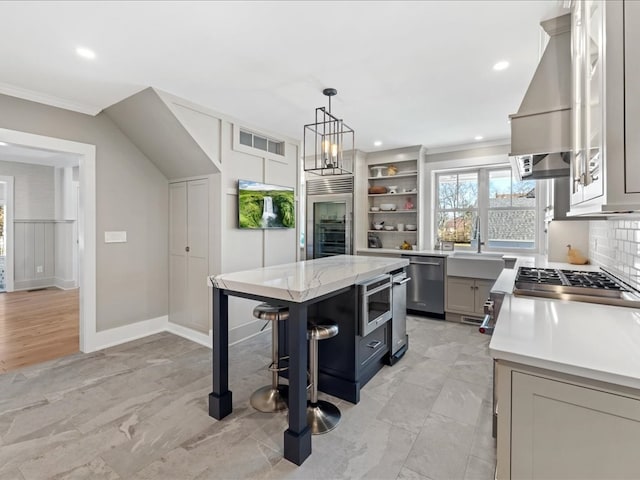 kitchen with gray cabinetry, backsplash, appliances with stainless steel finishes, and a center island