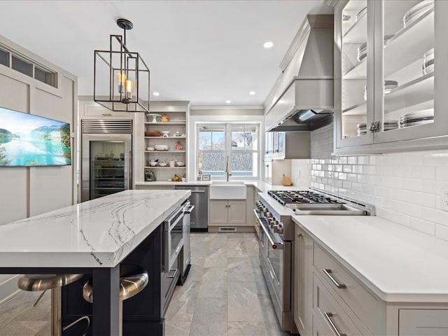 kitchen with a large island, appliances with stainless steel finishes, backsplash, gray cabinets, and pendant lighting