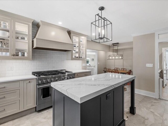 572 Jerusalem Rd, Cohasset, MA 02025 - kitchen with stainless steel range, custom exhaust hood, a kitchen island, decorative backsplash, and pendant lighting