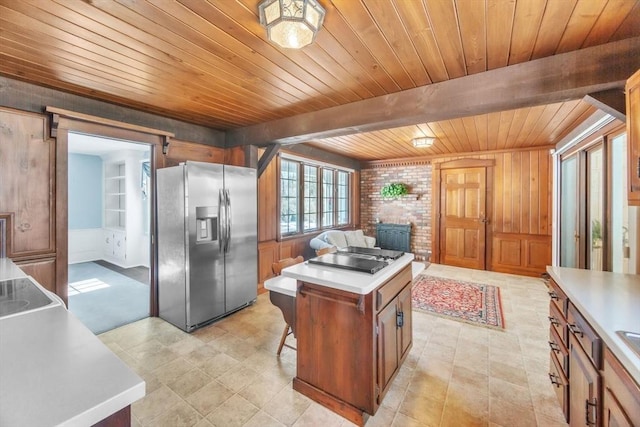 kitchen with cooktop, light countertops, stainless steel fridge with ice dispenser, and a barn door