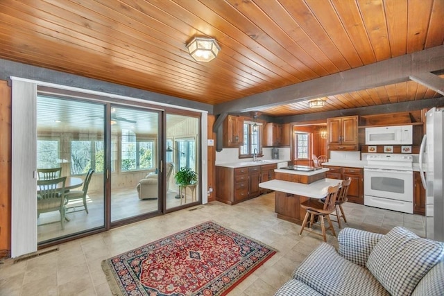 kitchen with brown cabinets, light countertops, visible vents, wood ceiling, and white appliances