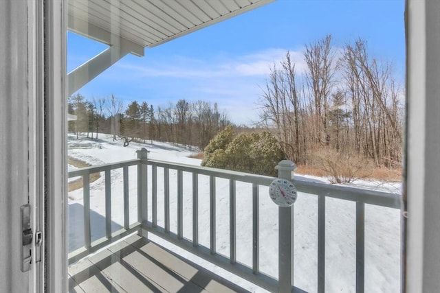 view of snow covered back of property