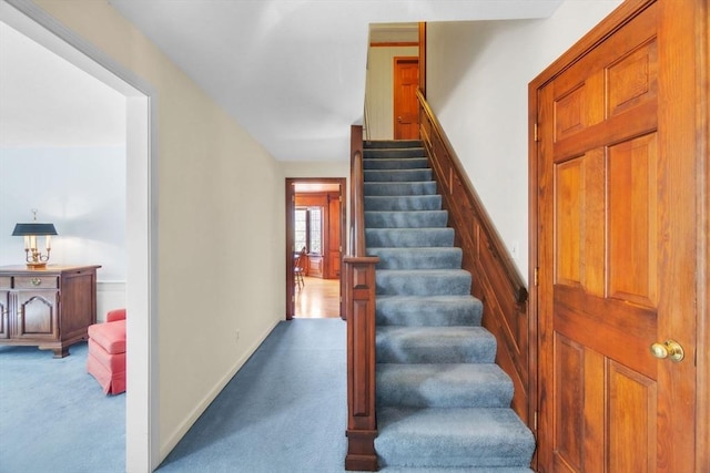 stairway featuring carpet and baseboards