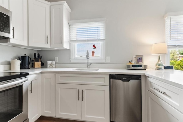 162 Willow Rd Unit 11, Nahant, MA 01908 - kitchen with appliances with stainless steel finishes, white cabinetry, and light countertops