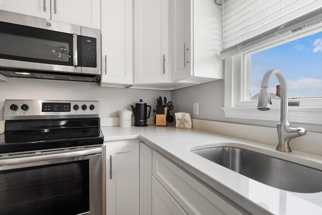 162 Willow Rd Unit 11, Nahant, MA 01908 - kitchen with stainless steel appliances, white cabinets, and light countertops