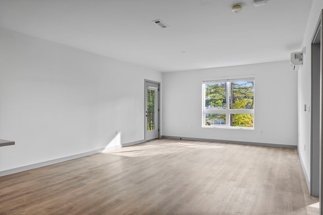 empty room featuring light hardwood / wood-style floors and a wall mounted air conditioner