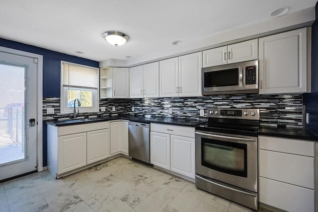 kitchen featuring marble finish floor, a sink, dark countertops, appliances with stainless steel finishes, and white cabinets