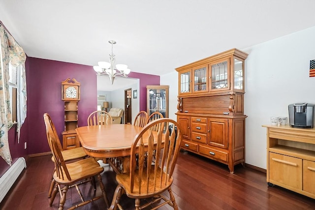 dining space featuring a baseboard heating unit, an inviting chandelier, dark wood finished floors, and baseboards