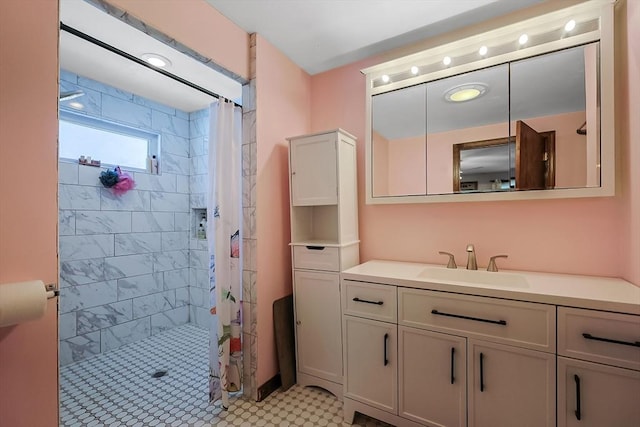 bathroom with tiled shower and vanity