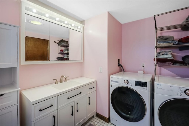 laundry room with washing machine and dryer, cabinet space, and a sink