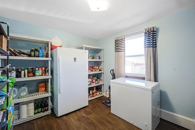 clothes washing area featuring a baseboard heating unit, a textured ceiling, and wood finished floors