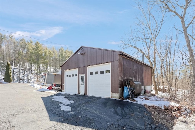 snow covered garage featuring a detached garage