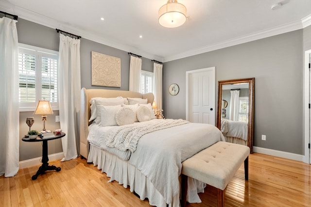 bedroom with crown molding, multiple windows, and light wood-type flooring