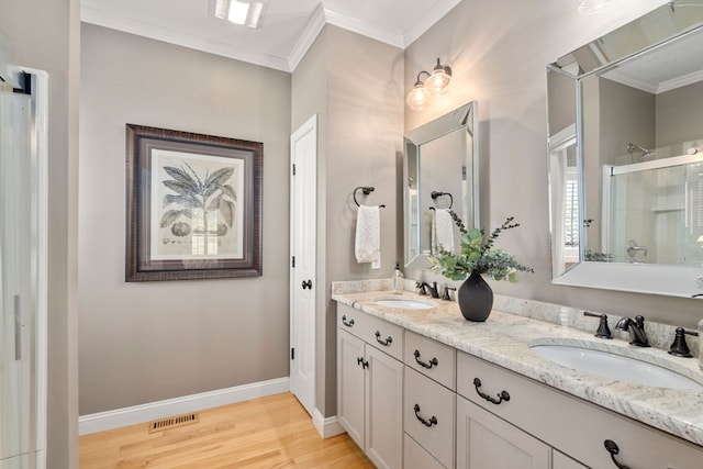 bathroom with vanity, crown molding, wood-type flooring, and a shower with shower door