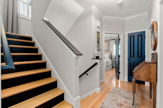 entrance foyer featuring crown molding and light hardwood / wood-style floors