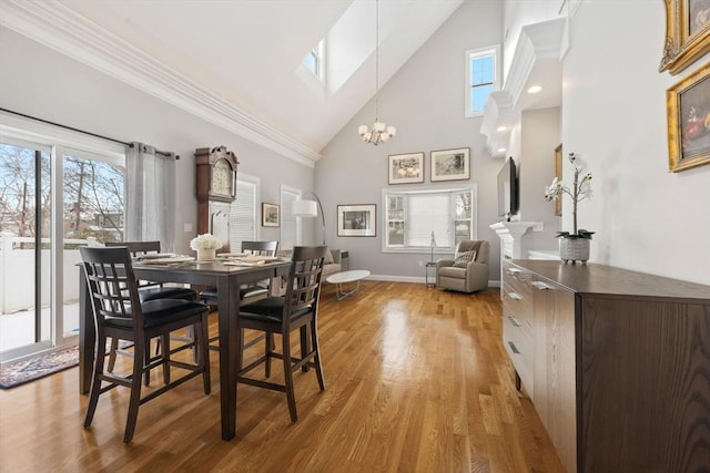 dining room featuring crown molding, a skylight, light wood-type flooring, and plenty of natural light