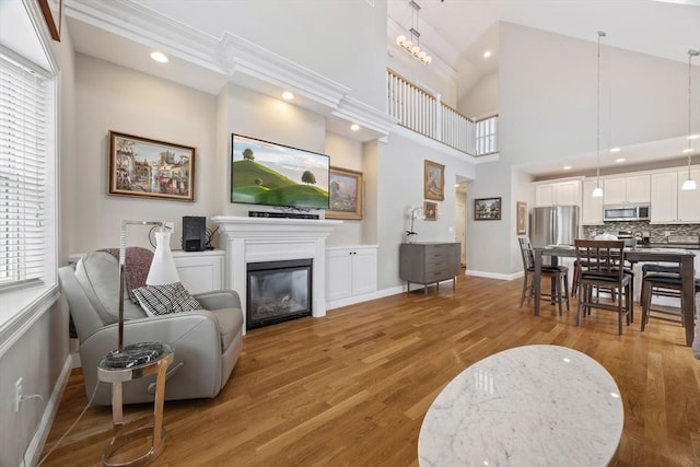 living room with a high ceiling and light hardwood / wood-style flooring