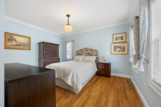 bedroom featuring ornamental molding and light hardwood / wood-style floors