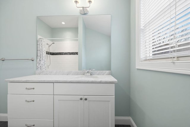 bathroom featuring tiled shower and vanity