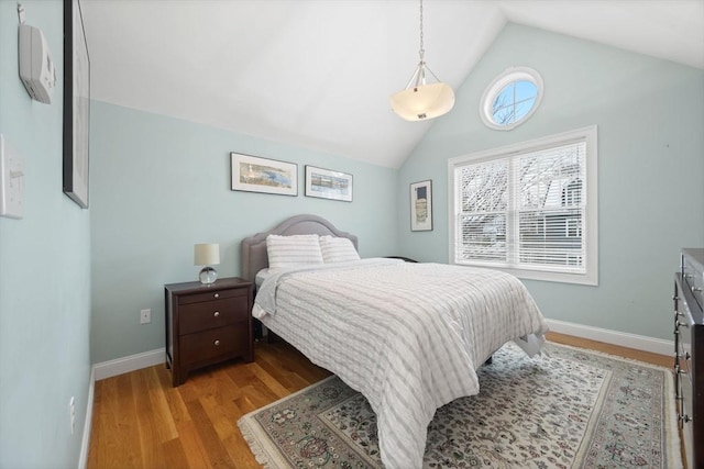 bedroom with light wood-type flooring and lofted ceiling