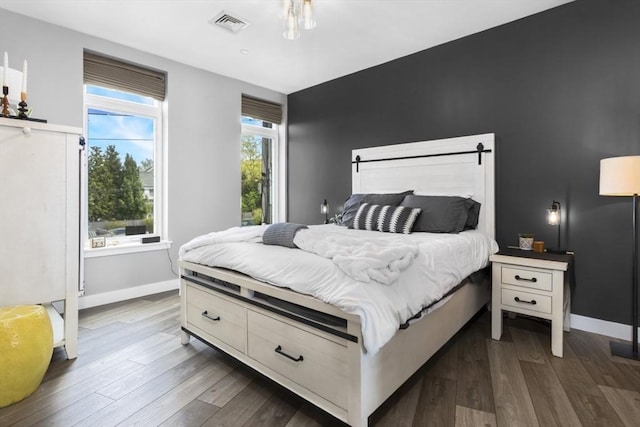 bedroom with dark wood-style floors and baseboards