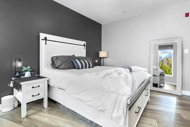 bedroom featuring wood finished floors and baseboards