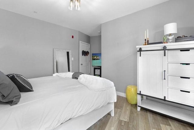 bedroom featuring light wood-style floors and baseboards