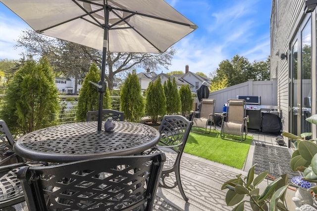 deck featuring outdoor dining space, a patio area, and fence