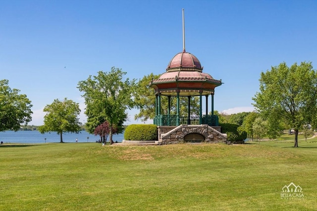 view of property's community with a lawn, a water view, and a gazebo