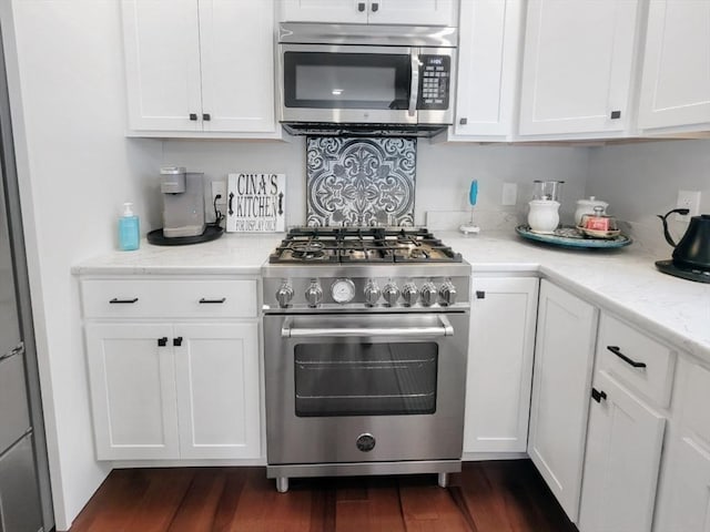 391 Gibbs St, Fall River, MA 02720 - kitchen featuring appliances with stainless steel finishes, white cabinetry, dark wood-style flooring, and light stone countertops