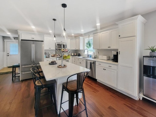 391 Gibbs St, Fall River, MA 02720 - kitchen with stainless steel appliances, a sink, recessed lighting, white cabinets, and a breakfast bar
