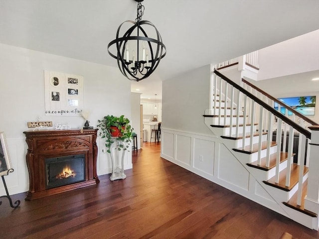 391 Gibbs St, Fall River, MA 02720 - stairs with wood finished floors, a chandelier, a glass covered fireplace, and a wainscoted wall