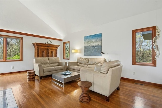 living room with wood finished floors, visible vents, vaulted ceiling, and baseboards