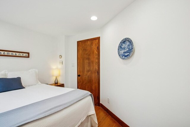 bedroom with recessed lighting, wood finished floors, and baseboards