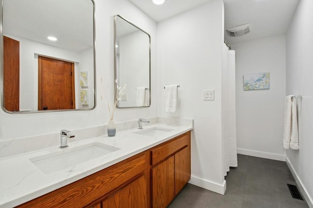 full bathroom with double vanity, visible vents, baseboards, and a sink